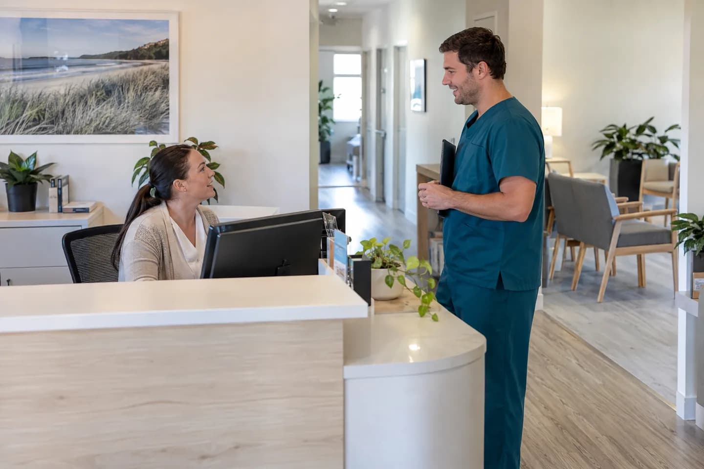 A receptionist and clinician coordinating work at an allied-health practice